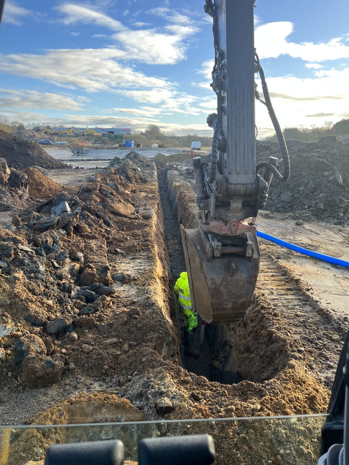 Gravemaskine graver dyb rende på byggeplads