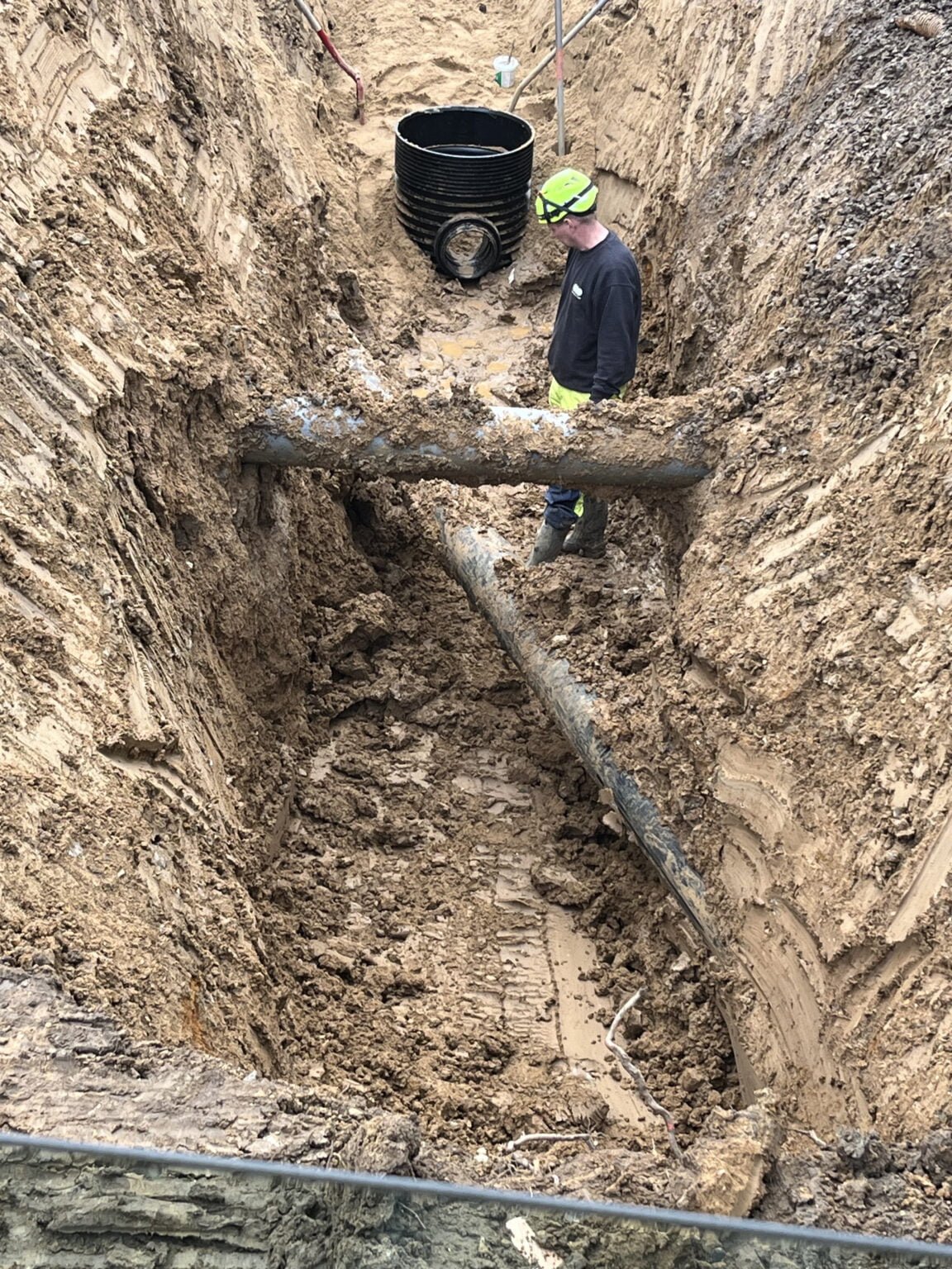 Arbejder undersøger rør i dyb byggegrav